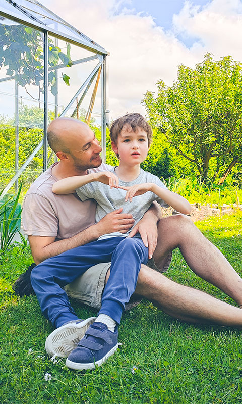 father and son sitting in garden